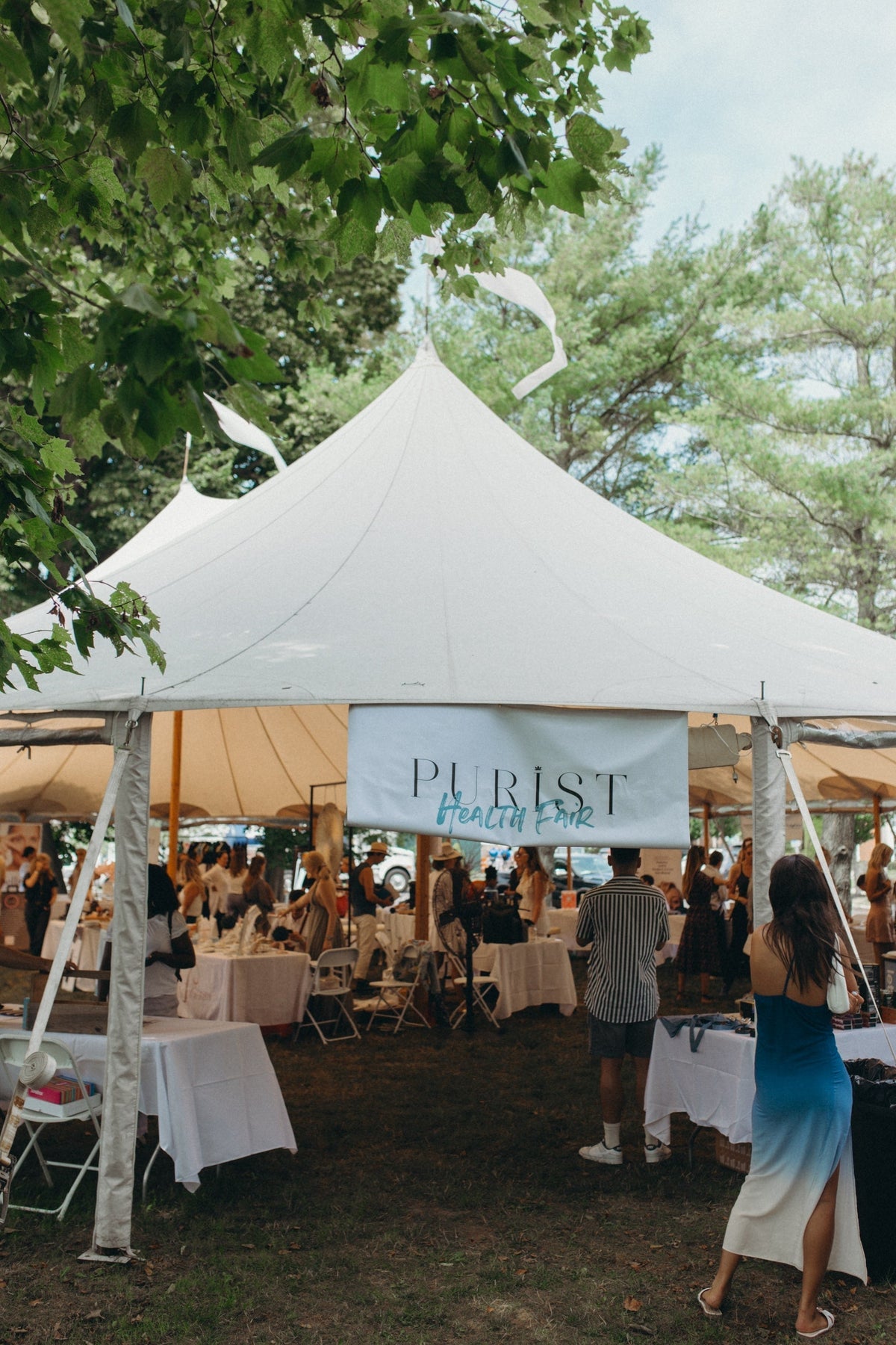 Tent at the Purist's 3rd Annual Health Fair with attendees enjoying the event outdoors.