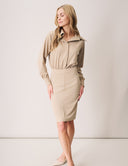 Stylish model wearing a Blossom Blouse Bodysuit with collared neckline and blouson sleeves in beige.