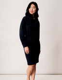 Model wearing a sleek black Blossom Blouse Bodysuit with long sleeves and fitted bottom.