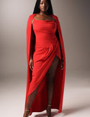 Come Closer dress featuring a ruched strapless neckline and high split-leg design, paired with a flowing red cape.