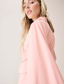 A model showcasing the Cool Intentions Blazer with batwing sleeves and satin lapels, highlighting its sleek design.
