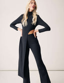 Model showcasing the Cut to the Chase Pant in a stylish black outfit with a unique cutout design.