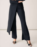 Woman wearing Cut to the Chase Pant with stylish split design and chic heels.