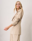 Model showcasing the Dahlia Blazer in beige, featuring peak lapels and a structured design for elegant style.