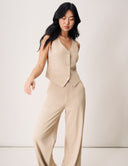 Model showcasing the Gardenia Vest with V-neckline and button closure, paired with stylish wide-leg pants.