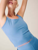 Model wearing a blue Luxe Tank Top, showcasing its cropped design and sleeveless style.