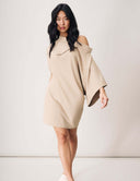 Model wearing the Modern Muse Dress in beige with off-the-shoulder styling and pockets.