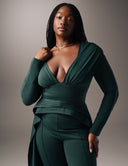 Woman wearing a deep V-neck Promise Me Nothing Top, showcasing a flattering silhouette and high-low hem.