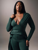 Woman wearing a deep V-neck Promise Me Nothing Top, showcasing a flattering silhouette and high-low hem.