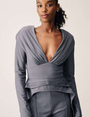Model wearing the Promise Me Nothing Top featuring a deep V-neckline and high-low hem in gray.