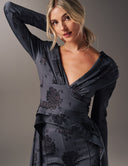 A model showcases the Promise Me Nothing Top with a deep V-neckline and elegant floral design.