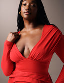 Model wearing the Promise Me Nothing Top, featuring a deep V-neckline and structured silhouette in bold red.