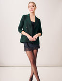 Starry Night Blazer: The Sustainable Edit in Dark Laurel paired with a stylish black dress and polka dot stockings.