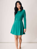 Model wearing a green Tulip Dress with long sleeves and a flared skirt, featuring a chic and elegant design.