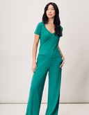 Model wearing a V-Neck Luxe Tee in green with wide-leg pants, showcasing refined style and comfort.