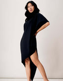 Woman in a black asymmetrical Willow Dress showcasing elegant draping and modern silhouette.