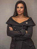 Podcast Host & Creator, Kanika Chadda-Gupta posing confidently in an elegant black dress with a stylish collar.
