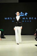 Model walking the runway in a black and white Enza Marie set featuring Mrs. Momma Bear branding at Vancouver Fashion Week.