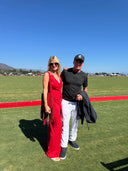 Co-Founder of Lonesome Wind Ranch, Amy Azzaro at a polo event in a red dress with a companion.