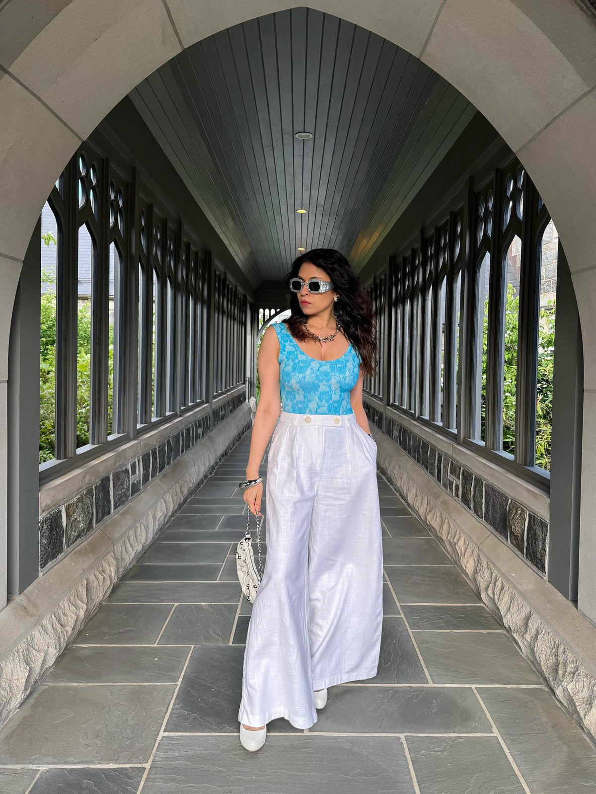 Content Creator, Arpana Moorjani posing in stylish outfit in a picturesque architectural corridor.