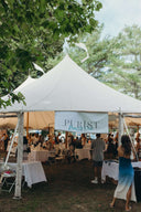 Tent at the Purist's 3rd Annual Health Fair with attendees enjoying the event outdoors.