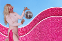 Barbie-inspired fashion featuring a Lee Evans Lee wearing Dancing Anyone holding a disco ball against a vibrant pink glitter background.