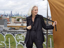 Stylish woman in Striped Nights Suit poses on a rooftop with a city skyline backdrop, exuding confidence and fashion.