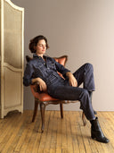 Woman in Dark Denim Nights  seated elegantly on a vintage chair, showcasing a modern yet classic fashion vibe.