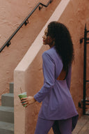 Woman in open back tux jacket from Keep It Moving Set - Wisteria, holding a green drink