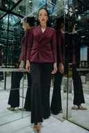 A model wearing the Starry Night Blazer: The Sustainable Edit with flared pants in a stylish mirrored environment.