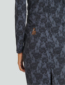 Close-up of Black Widow featuring intricate black floral lace pattern and a golden logo on the pocket.