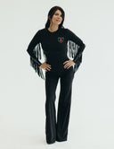 Model wearing Fringy Baby jumpsuit with fringe sleeves and front pocket, blending rodeo style with modern fashion.