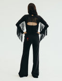 Back view of Fringy Baby jumpsuit with fringe details on sleeves and open back, showcasing flower embroidery and pockets.