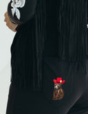 Close-up of Fringy Baby jumpsuit back pocket featuring a bear in a red cowboy hat and fringe detailing.