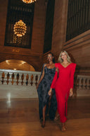 Models showcasing the Come Closer dress collection in a lavish setting with elegant chandeliers.