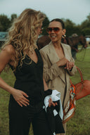 Two women wearing stylish outfits, one in a Magnolia Vest, enjoying a sunny day outdoors.