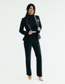 Model wearing a stylish black three-piece suit with a fitted cropped top and slim cut pants for ultimate comfort.