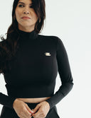 Woman in a black fitted long sleeve cropped top with a cup pin, showcasing comfort and style for everyday wear.