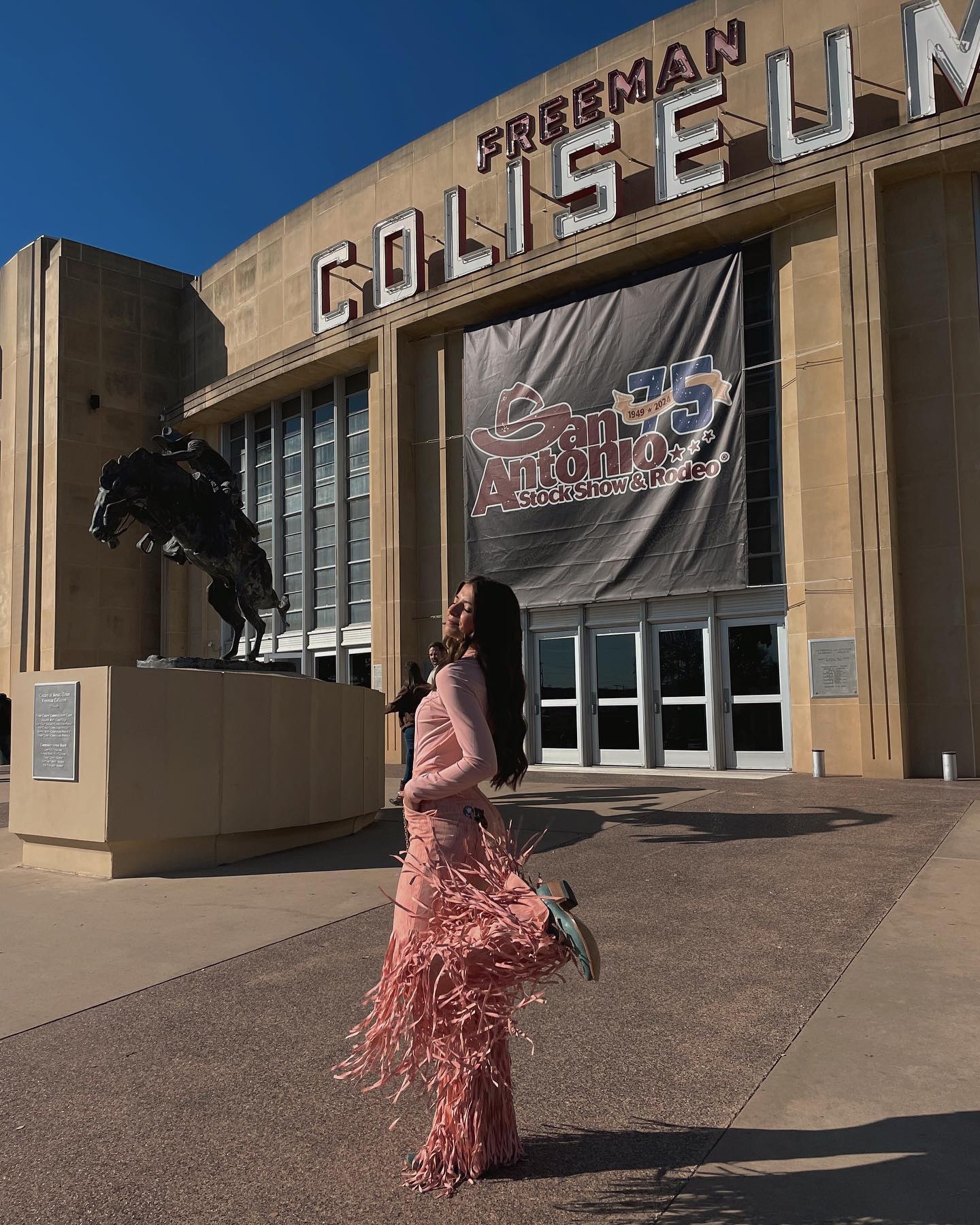 Woman in Dancing Anyone poses in front of the Freeman Coliseum in San Antonio, Texas.