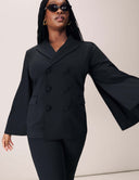 Model wearing the Cool Intentions Blazer featuring batwing sleeves and satin lapels, styled with chic sunglasses.