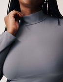 Close-up of woman wearing the Cut to the Chase Top in gray with mock neck and sleek fit.