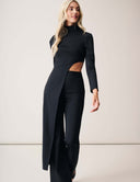Model showcasing the Cut to the Chase Pant in black, featuring a stylish cut-out design and long sleeves.