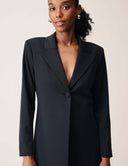 Front view of a woman wearing the Keep It Moving Blazer with an open back tuxedo silhouette and elegant lapel.