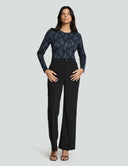 Luxe Long Sleeve Bodysuit in black lace print paired with tailored black pants, showcasing stylish comfort and versatility.