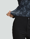 Close-up of Luxe Long Sleeve Bodysuit in black lace fabric, showcasing fit and style paired with sleek black pants.