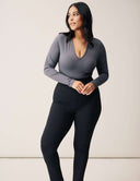 Model wearing Luxe Long Sleeve Bodysuit with a scoop neckline and sleek black bottoms for versatile styling.