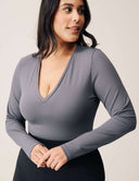 Model wearing a Luxe Long Sleeve Bodysuit in grey, showcasing a flattering scoop neckline and long sleeves.
