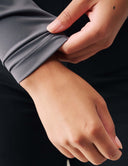 Detail of a hand adjusting the cuff of the Luxe Long Sleeve Bodysuit, showcasing its comfortable fit.