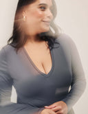 Model wearing the Luxe Long Sleeve Bodysuit with a flattering scoop neckline and stylish details.