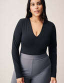 Model showcasing the Luxe Long Sleeve Bodysuit with a flattering scoop neckline and seamless fit.
